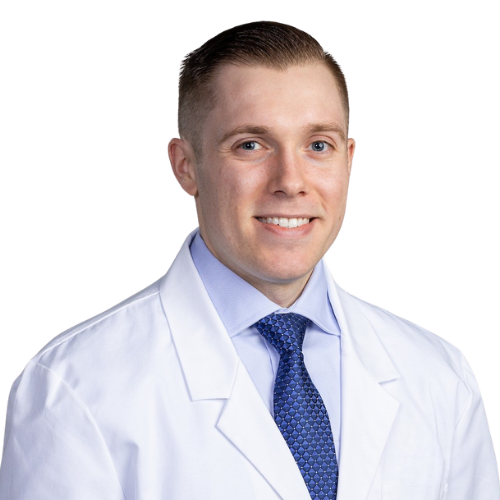 Portrait of a smiling male doctor in a white coat and blue tie against a white background, looking at the camera.